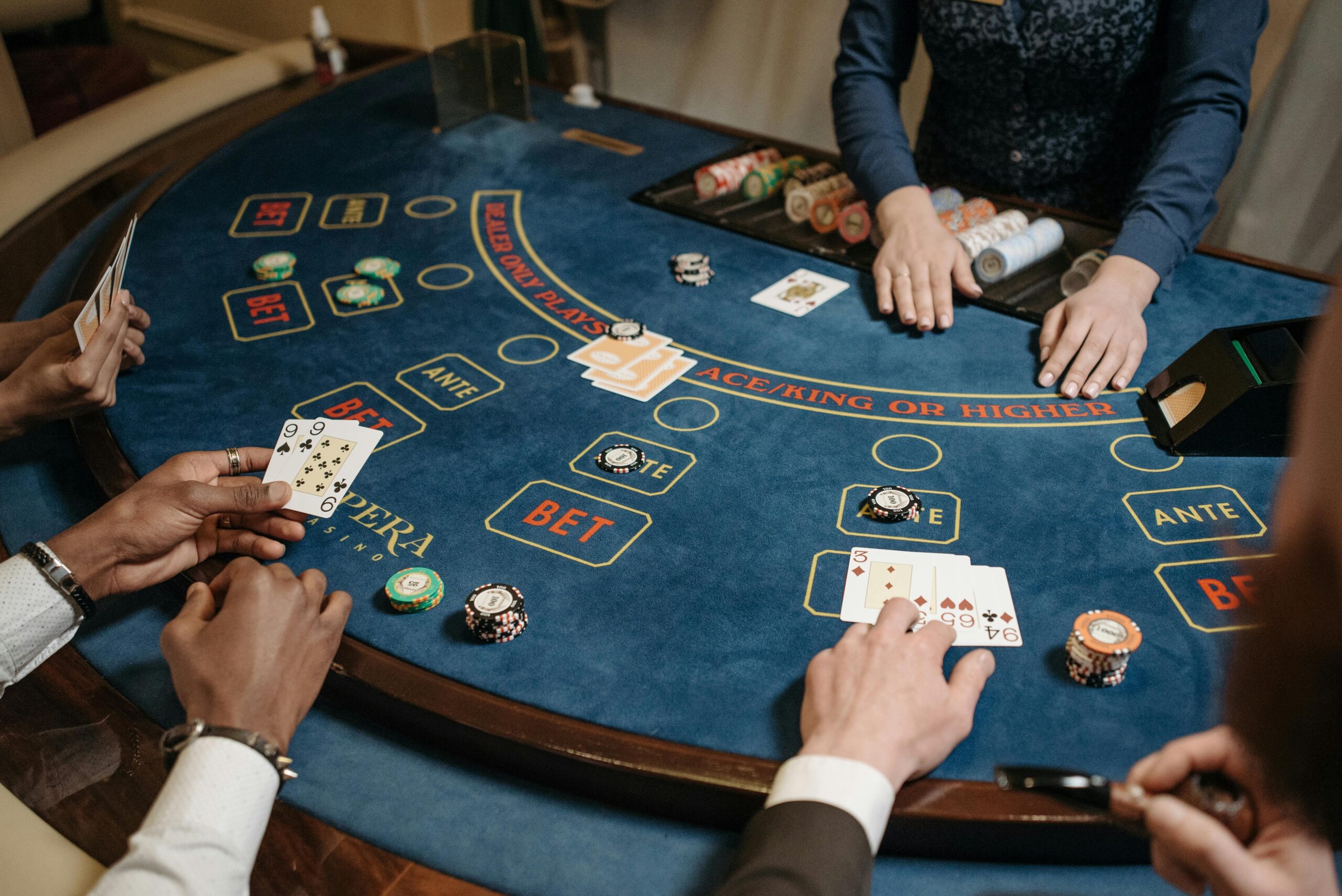 People playing a lively card game at a casino table with chips and a dealer.